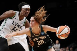 Guard Sabrina Ionescu #20 of the New York Liberty dribbles as center Sylvia Fowles #34 of the Minnesota Lynx defends.
