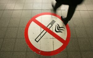 A passenger walks on a no-smoking sign at the Potsdamer Platz train station in Berlin
