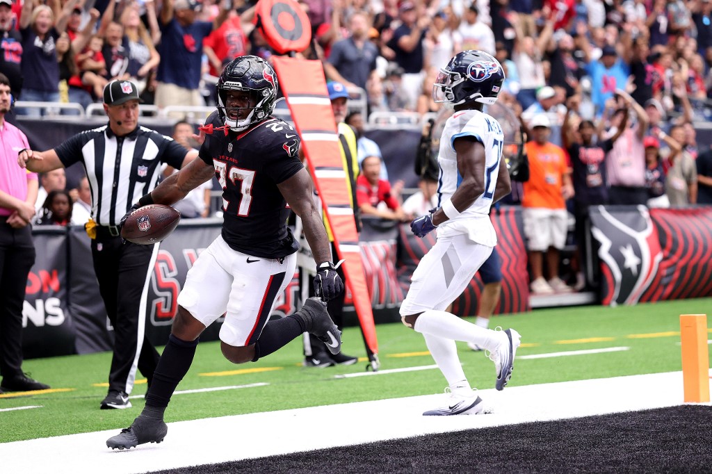 Woody Marks #27 of the Houston Texans scores a touchdown against Roger McCreary #21 of the Tennessee Titans