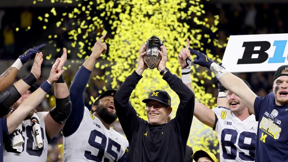 Head-coach-Jim-Harbaugh-of-the-Michigan-Wolverines-celebrates-with-the-trophy-after-the-Michigan-Wolverines-defeated-the-Iowa-Hawkeyes-42-3-to-win-the-Big-Ten-Championship-aspect-ratio-16-9