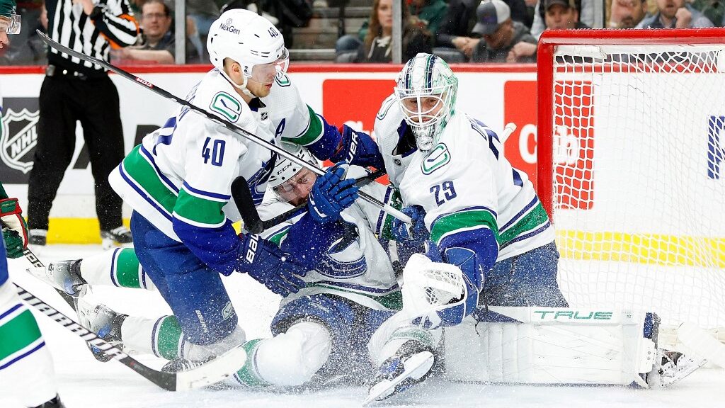 Elias-Pettersson-40-and-Filip-Hronek-17-collide-with-Casey-DeSmith-29-of-the-Vancouver-Canucks-against-the-Minnesota-Wild-aspect-ratio-16-9