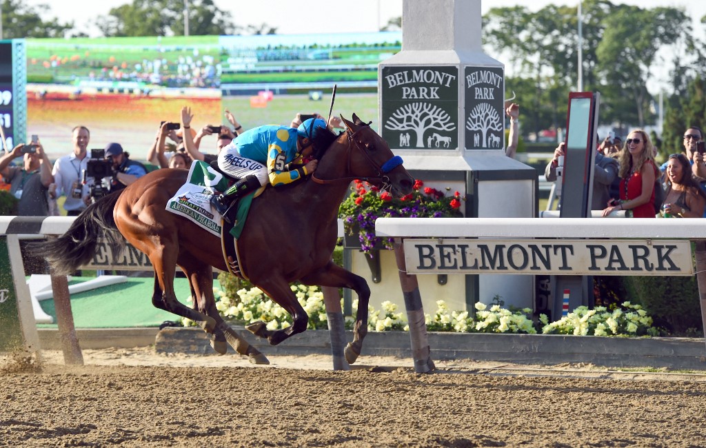 American Pharoah ridden by Victor Espinoza crosses the finish line to win the 147th Belmont Stakes at Belmont Park on June 6, 2015 in Elmont, New York