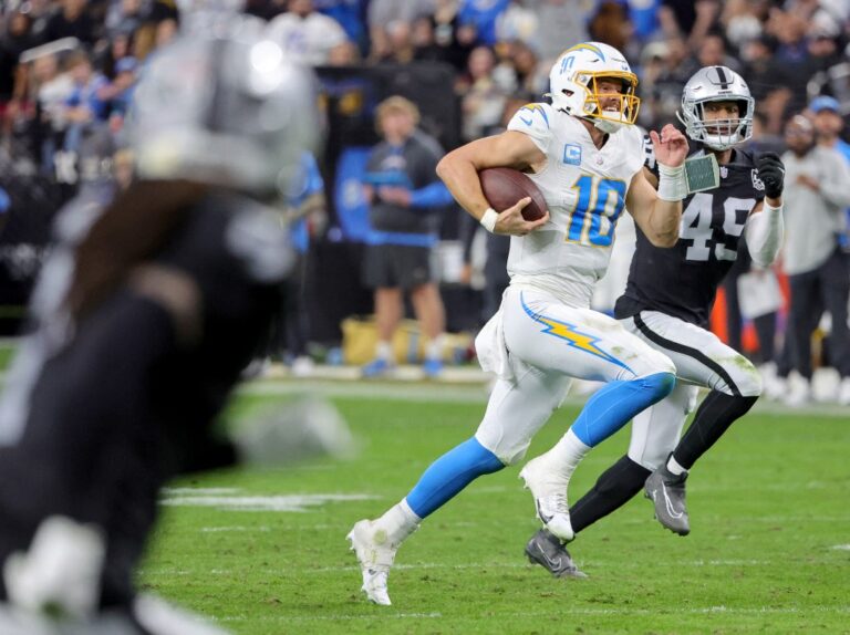 Justin Herbert #10 of the Los Angeles Chargers runs the ball against the Las Vegas Raiders.