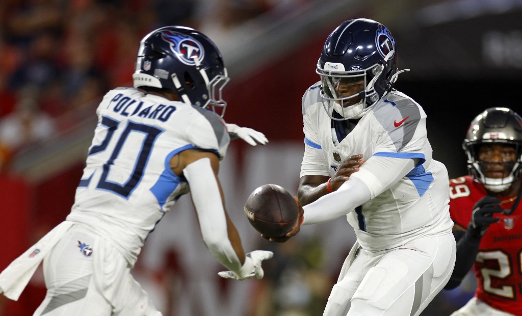 Cameron Ward #1 of the Tennessee Titans hands off to running back Tony Pollard #20