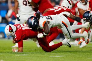 Nik Bonitto #15 of the Denver Broncos sacks Clayton Tune #15 of the Arizona Cardinals