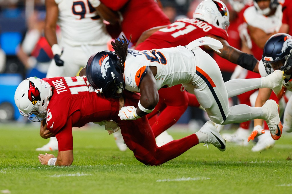Nik Bonitto #15 of the Denver Broncos sacks Clayton Tune #15 of the Arizona Cardinals