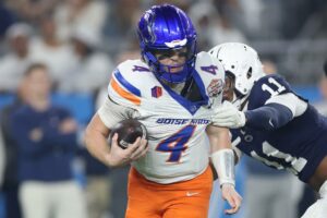 Maddux Madsen #4 of the Boise State Broncos attempts to avoid a tackle by Abdul Carter #11 of the Penn State Nittany Lions during the second quarter in the 2024 Vrbo Fiesta Bowl