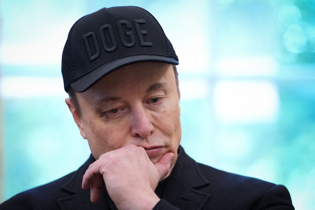 Tesla CEO Elon Musk listens as U.S. President Donald Trump speaks to reporters