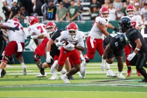 Ezekiel Avit #84 of the Fresno State Bulldogs runs the ball before being tackled by Jalen Smith #3 of the Hawaii Rainbow Warriors