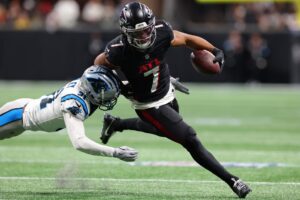 Bijan Robinson #7 of the Atlanta Falcons runs the ball against Caleb Farley #31 of the Carolina Panthers