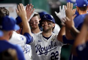 Carter Jensen #22 of the Kansas City Royals is congratulated by teammates in the dugout after hitting his first Major League home run
