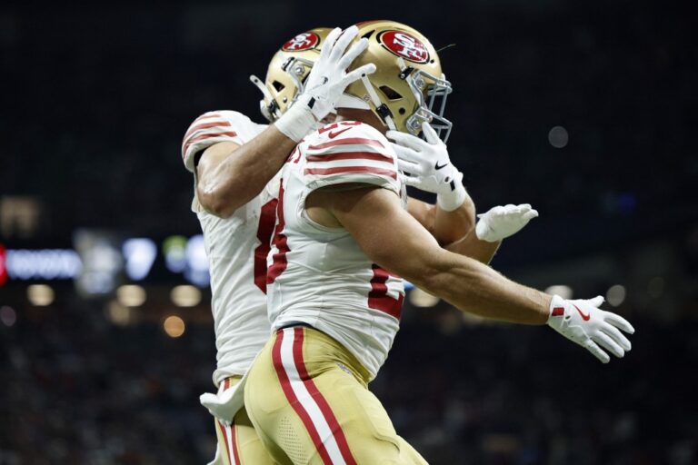 Christian McCaffrey #23 of the San Francisco 49ers is congratulated by Jake Tonges #88.
