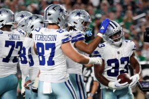 Javonte Williams #33 of the Dallas Cowboys celebrates with teammates after scoring his second one yard touchdown against the Philadelphia Eagles