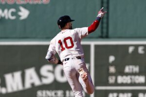 Trevor Story #10 of the Boston Red Sox signals to his bullpen as he rounds the bases after his home run against the Athletics