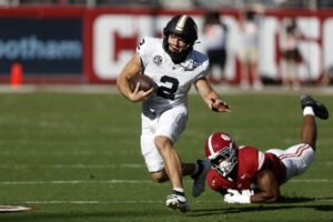 Diego Pavia #2 of the Vanderbilt Commodores gets around Nikhai Hill-Green #41 of the Alabama Crimson Tide as he carries the ball