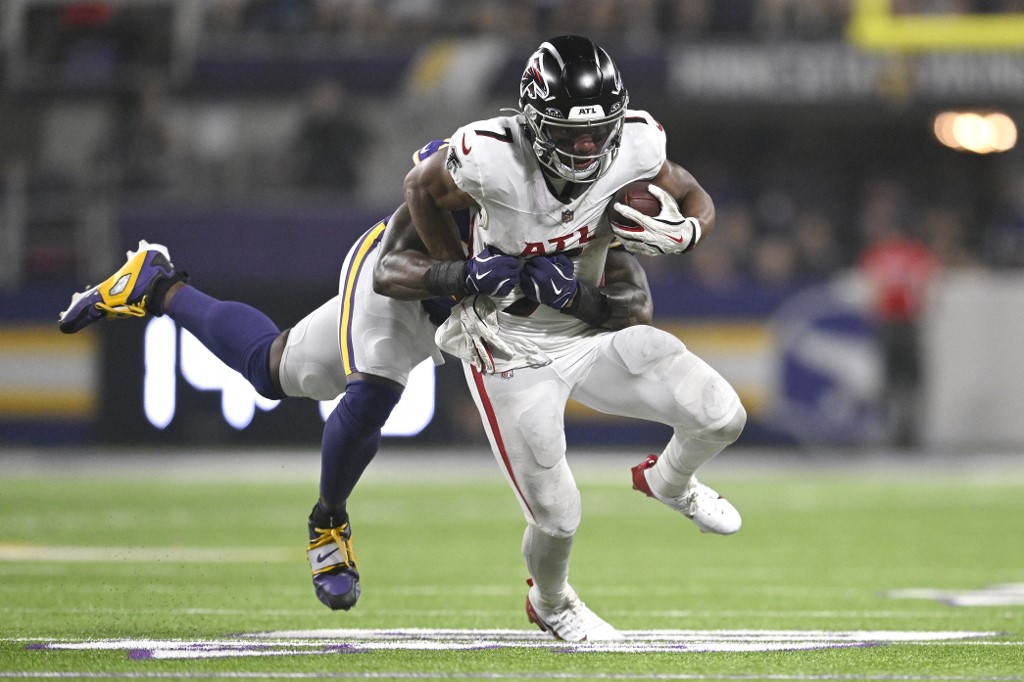 Bijan Robinson #7 of the Atlanta Falcons is tackled by Dallas Turner #15 of the Minnesota Vikings.