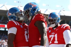 Trinidad Chambliss, Dae'Quan Wright and PJ Wilkins #71 of the Mississippi Rebels celebrate after a touchdown against the Washington State Cougars.
