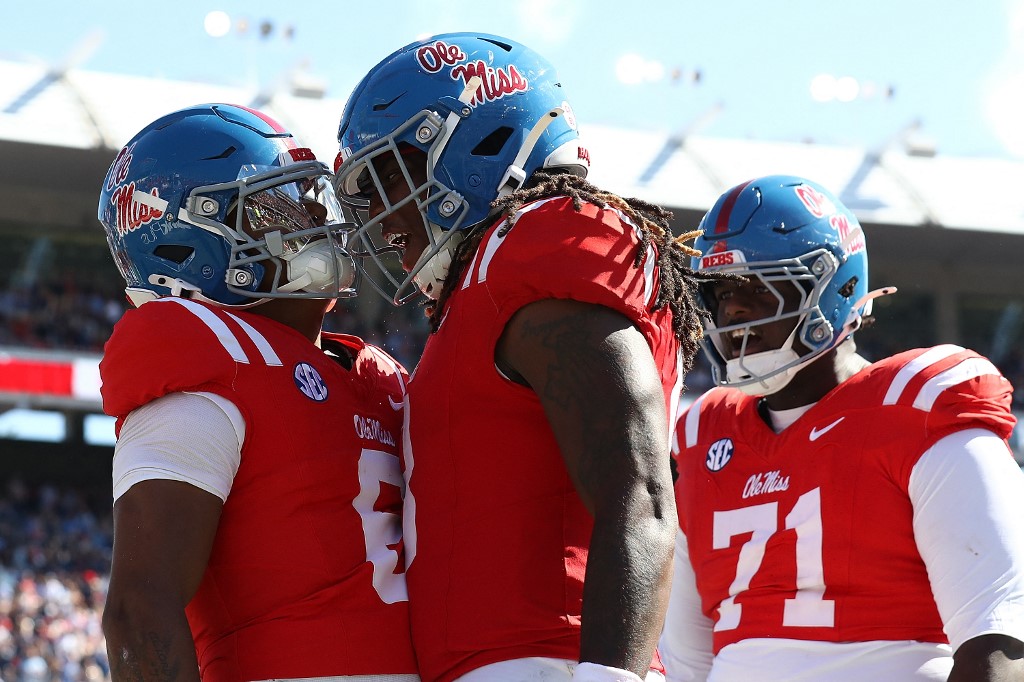 Trinidad Chambliss, Dae'Quan Wright and PJ Wilkins #71 of the Mississippi Rebels celebrate after a touchdown against the Washington State Cougars.