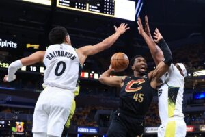 Donovan Mitchell #45 of the Cleveland Cavaliers takes a shot against Tyrese Haliburton #0 and Myles Turner #33 of the Indiana Pacers