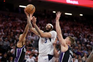 Anthony Davis #3 of the Dallas Mavericks goes up for a shot on Keegan Murray #13 and Domantas Sabonis #11 of the Sacramento Kings