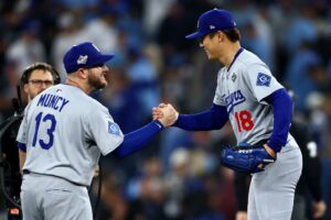 Max Muncy #13 of the Los Angeles Dodgers celebrates with Yoshinobu Yamamoto #18 after pitching a complete game to defeat the Toronto Blue Jays.