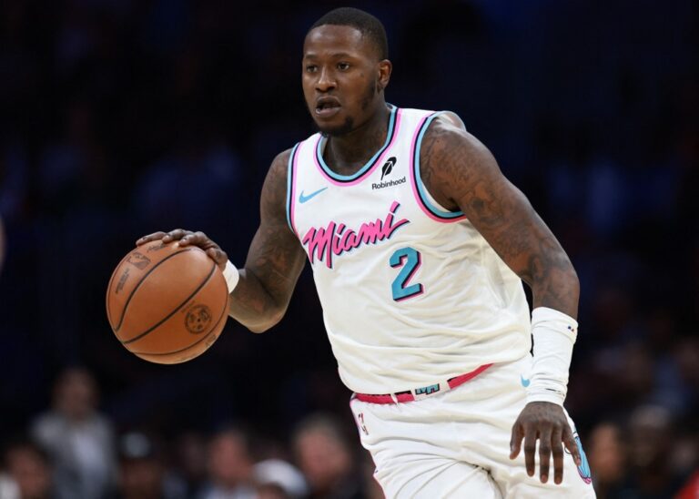 Terry Rozier #2 of the Miami Heat controls the ball against Kristaps Porzingis #8 of the Boston Celtics.
