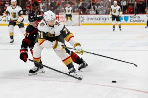 William Karlsson #71 of the Vegas Golden Knights skates with the puck against Alexander Nikishin #21 of the Carolina Hurricanes