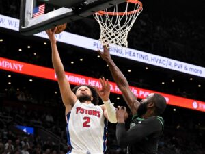Cade Cunningham #2 of the Detroit Pistons attempts a basket against Jaylen Brown #7 of the Boston Celtics.