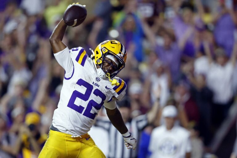 The cover of this college football player props week 11 article shows running back Harlem Berry #22 of the LSU Tigers celebrating after scoring a touchdown during the first half of a game against the Texas A&M Aggies
