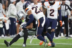 Brandon Jones #22 of the Denver Broncos tackles Tre Tucker #11 of the Las Vegas Raiders. Broncos vs. Raiders is our featured game for this week's Thursday night football picks.