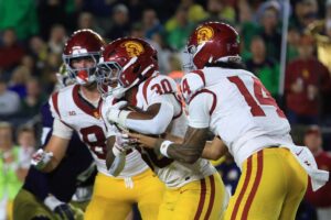 Jayden Maiava #14 of the USC Trojans, our top Friday night college football pick, hands the ball off to King Miller #30 during the game against the Notre Dame Fighting Irish.
