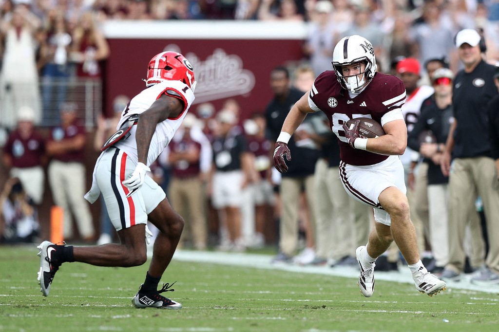 The cover for this college football picks article shows Sam West #87 of the Mississippi State Bulldogs carrying the ball against Ellis Robinson IV #1 of the Georgia Bulldogs