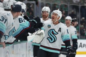 Jaden Schwartz #17 of the Seattle Kraken is congratulated by teammates on his bench after scoring a goal during the first period against the Dallas Stars.