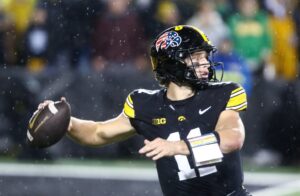 Quarterback Mark Gronowski of the Iowa Hawkeyes, featured in our Saturday college football bets, throws a pass against the Oregon Ducks.