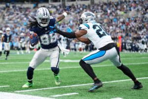 The cover for this Monday night football picks article shows CeeDee Lamb #88 of the Dallas Cowboys running after a catch against Jordan Fuller #20 of the Carolina Panthers