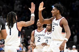 The UConn Huskies, featured in our College basketball picks today, celebrate against the BYU Cougars.