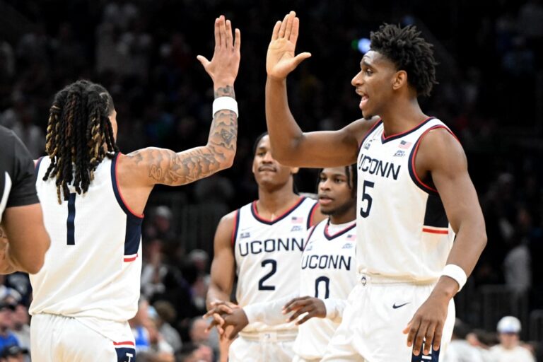 The UConn Huskies, featured in our College basketball picks today, celebrate against the BYU Cougars.