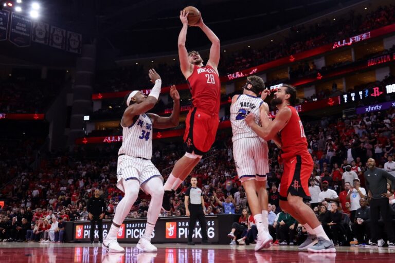The cover for this NBA player props today article shows Alperen Sengun #28 of the Houston Rockets going up against Wendell Carter Jr. #34 of the Orlando Magic