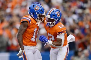 Marvin Mims Jr. #19 and RJ Harvey #12 of the Denver Broncos celebrate after Harvey's rushing touchdown against the Dallas Cowboys.