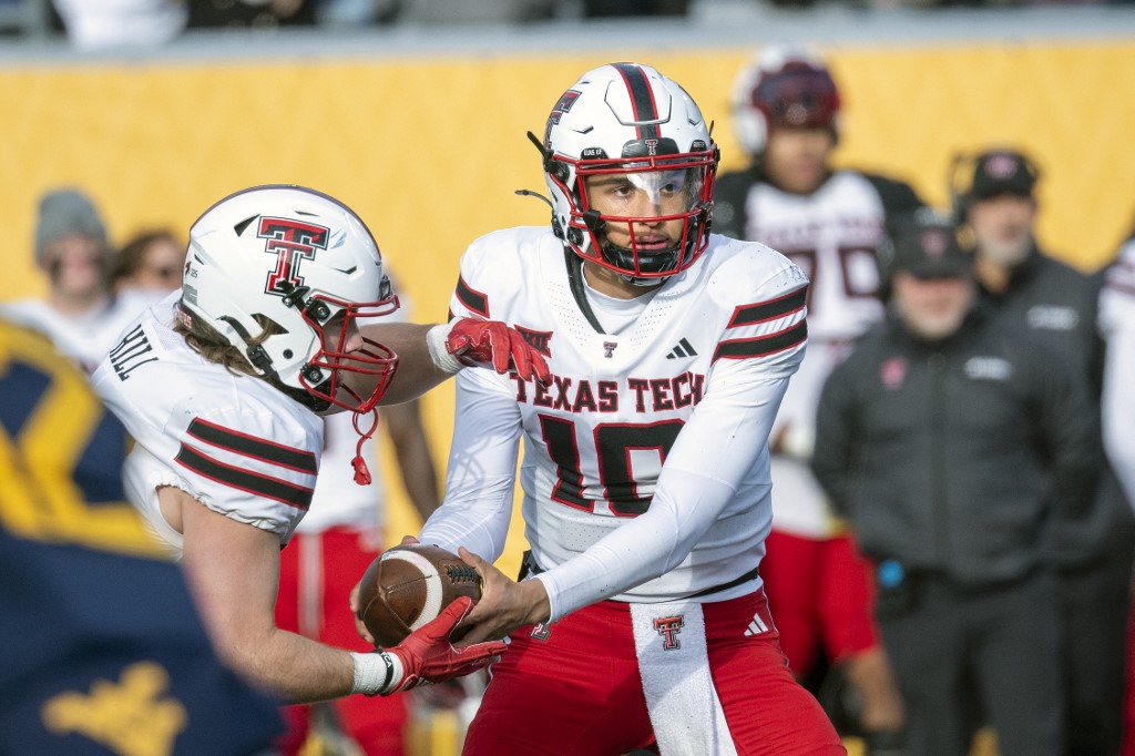 Loyd Jones III #10 of the Texas Tech Red Raiders motions to hand the ball off in the third quarter during the game against the West Virginia Mountaineers.