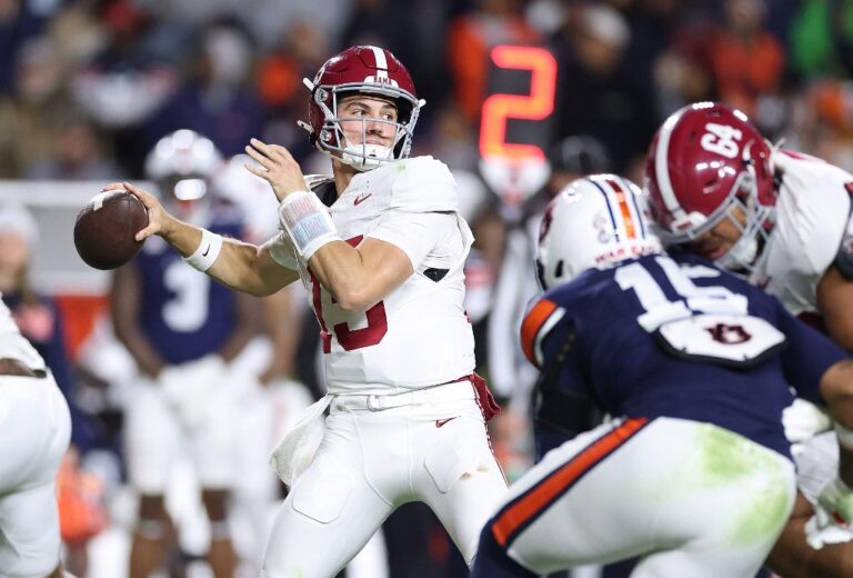 The cover for this Saturday night college football picks article shows Ty Simpson #15 of the Alabama Crimson Tide looks to pass against the Auburn Tigers.