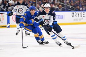 The cover for this NHL picks today article shows Kyle Connor #81 of the Winnipeg Jets controling the puck against Peyton Krebs #19 of the Buffalo Sabres.