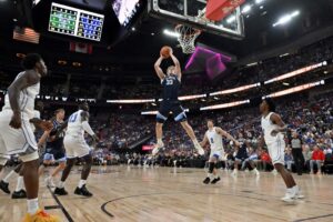 The cover for this college basketball picks today article shows Matt Hodge #33 of the Villanova Wildcats grabbing a rebound against the BYU Cougars.