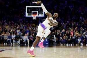 The cover for this NBA player props today article shows Lebron James #23 of the Los Angeles Lakers reacting after shooting a three-pointer against the Philadelphia 76ers.