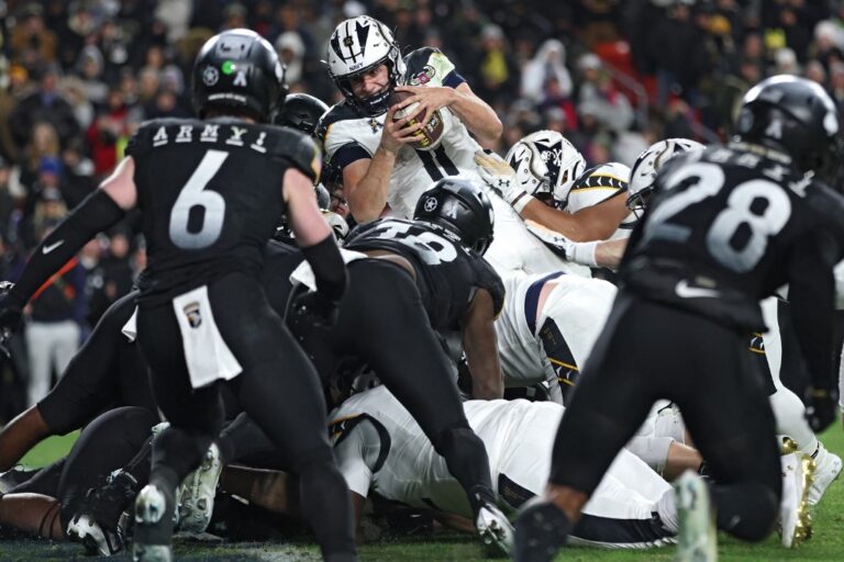 Quarterback Blake Horvath #11 of the Navy Midshipmen scores a touchdown against the Army Black Knights.