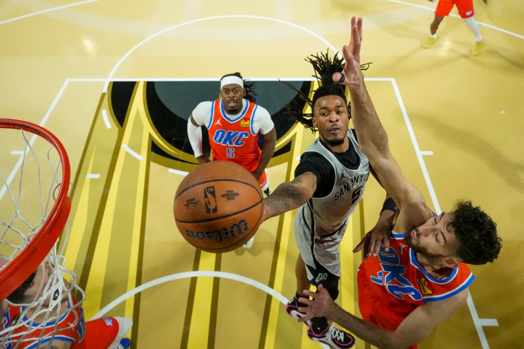 The cover for this NBA player props today article shows Stephon Castle #5 of the San Antonio Spurs drives to the basket on Chet Holmgren #7 of the Oklahoma City Thunder.