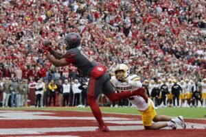 The cover for this College football picks bowls article shows Wide receiver Javonnie Gibson #11 of the Oklahoma Sooners catching an 11-yard touchdown pass against cornerback Drey Norwood #12 of the Missouri Tigers.