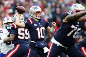 The cover for this Sunday night football picks article shows Drake Maye #10 of the New England Patriots in action against the Buffalo Bills.