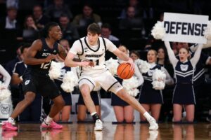 Ryan Mela #11 of the Providence Friars dribbles against Kolby King #12 of the Butler Bulldogs.