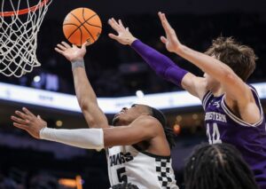 The cover for this NCAA basketball picks today article shows Michael Ajayi #5 of the Butler Bulldogs shooting the ball against Angelo Ciaravino #44 of the Northwestern Wildcats.